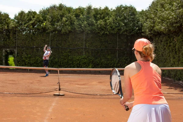 Kvinnlig tennisspelare utbildning med tränare på lera domstol, sport koncept — Stockfoto