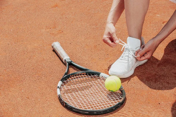 Tennisspelare på en gör sig redo binda skor snören innan hennes professionella match, sport koncept — Stockfoto
