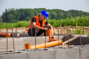 İnşaat müdürü evin yeni bungalov temelini, bina konseptini kontrol ediyor.
