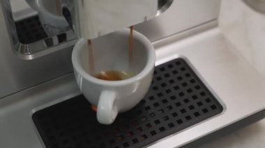 Otomatik kahve makinesinden beyaz bardakta espresso yapmak.