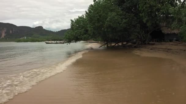 Літаючий безпілотник над пляжем з блакитною водою і жовтим піском, вид зверху — стокове відео