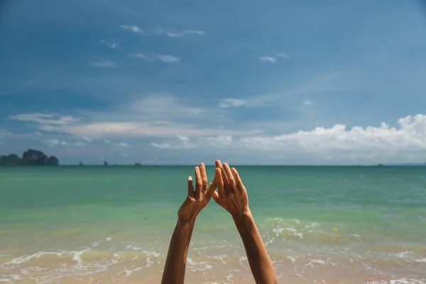 Las manos de la chica en el fondo mar turquesa y el cielo azul —  Fotos de Stock