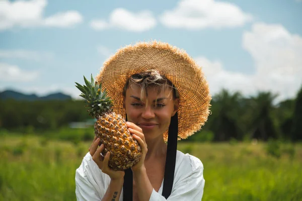 Mädchen mit Ananas in der Hand, in einem weißen Kleid — Stockfoto