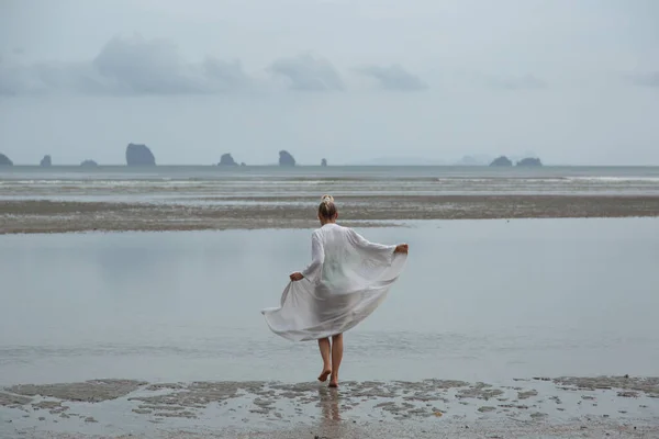 Chica en vestido blanco va en la arena en el fondo de la playa de las Islas —  Fotos de Stock