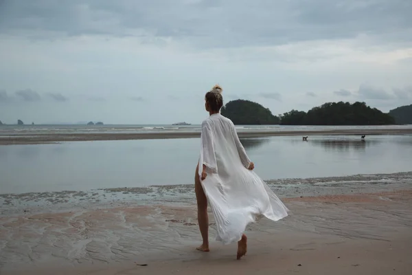 Chica en vestido blanco va en la arena en el fondo de la playa de las Islas —  Fotos de Stock