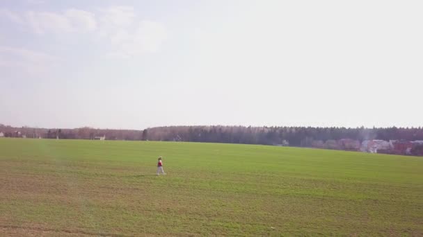 Samotna dziewczyna na polu, kamera krąży wokół niej — Wideo stockowe