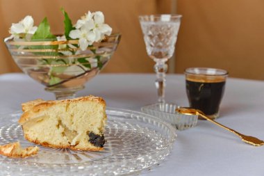 Elmalı turta, dondurma ve kahve, masanın üstünde. Vazodaki çiçekler.