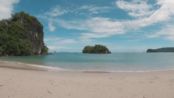 Bater lentamente na câmera com vista para as ilhas e rochas em uma praia arenosa — Vídeo de Stock