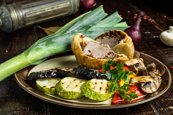 Grilled meat and vegetables on rustic wooden table	close up