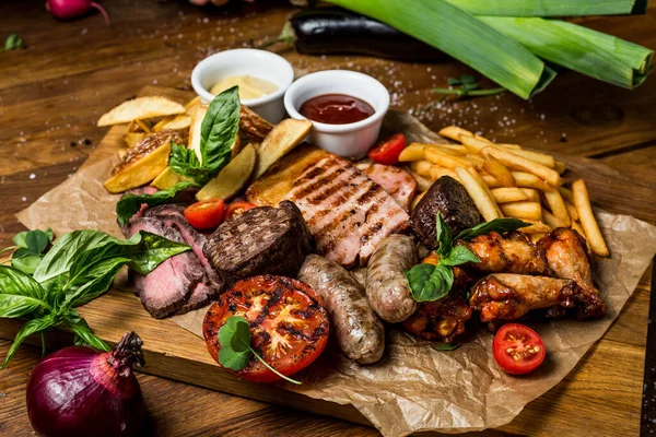 Grilled meat and vegetables on rustic wooden table	top view