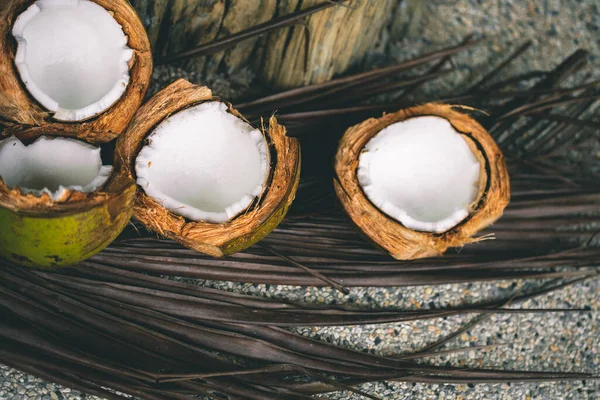 Kaputte Kokosnüsse Auf Einem Holztisch Mit Palmblättern Aus Nächster Nähe — Stockfoto