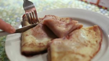 Bıçakla kesilmiş tabakta reçelli krep.