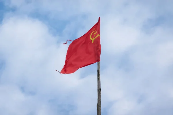 雲と空の背景に赤いソビエトの旗 フラグは バッター状の外観をしています 鎌とハンマーの印がある — ストック写真