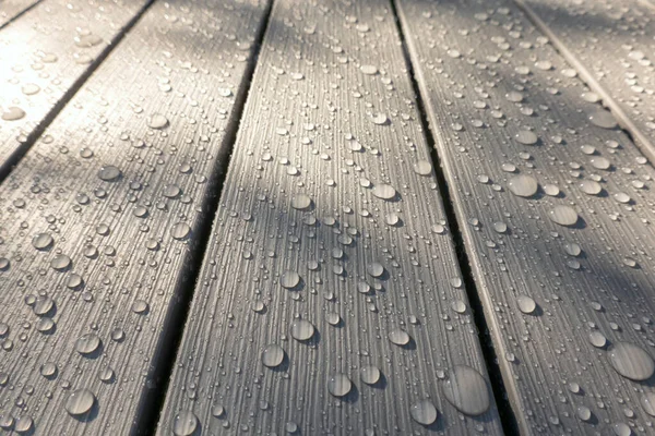 灰色のプラスチック製のスラットの視点を見てください 表面には木の質感の模倣があります 雨の後に水の滴があります テクスチャ — ストック写真