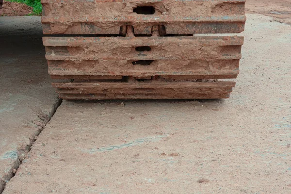 Die Raupe Eines Baufahrzeugs Steht Auf Einer Betonplattenbaustelle Die Stahlschienen — Stockfoto