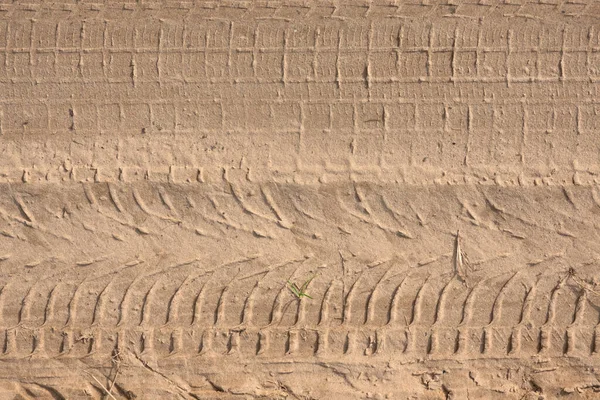 不同的车辙在沙地路上留下的痕迹 有一些皱巴巴的草叶 — 图库照片