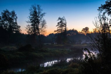 Sis, Güneş doğmadan önce nehirde. Bulutlar güneşin ilk ışınları gelen sıcak bir parlaklık.