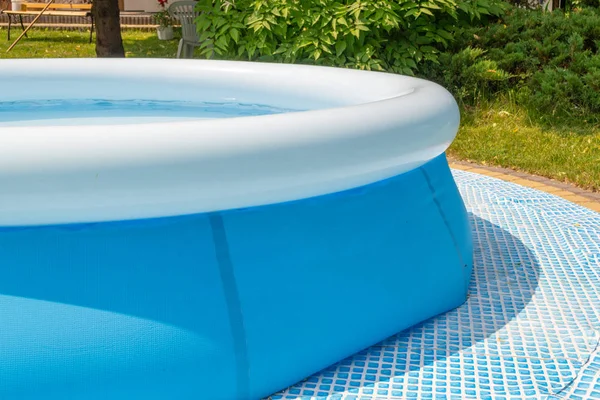 A round, blue, garden pool for children.