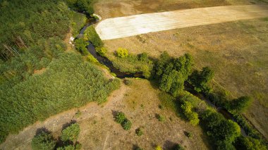 Orta Polonya'da küçük bir nehir, yeşil çayırlar ve ormanlar arasında akan
