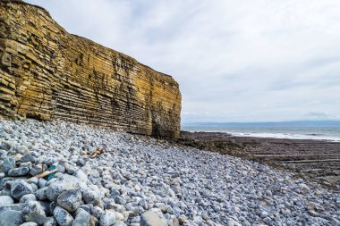 Galler - günbatımında kıyıda yaban kayalıklar ve kayalık kıyılar.