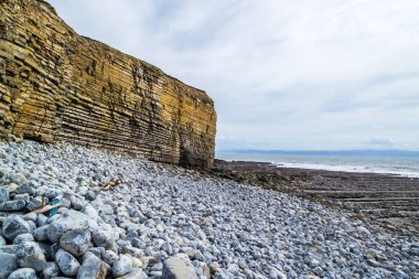 Galler - günbatımında kıyıda yaban kayalıklar ve kayalık kıyılar.