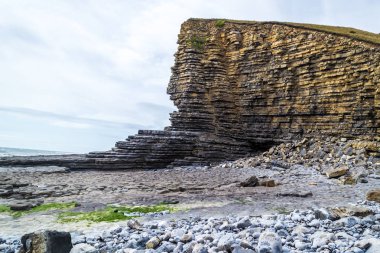 Galler - günbatımında kıyıda yaban kayalıklar ve kayalık kıyılar.
