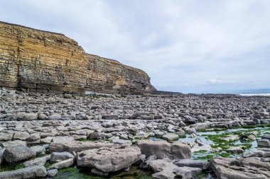 Galler - günbatımında kıyıda yaban kayalıklar ve kayalık kıyılar.