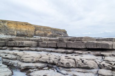 Galler - günbatımında kıyıda yaban kayalıklar ve kayalık kıyılar.
