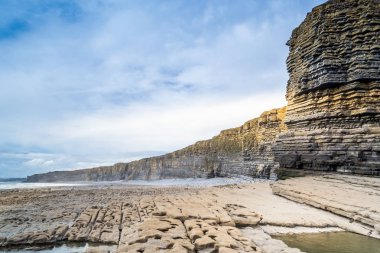 Galler - günbatımında kıyıda yaban kayalıklar ve kayalık kıyılar.