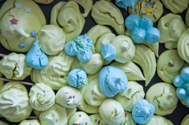 beze üstten görünüm arka plan. Deniz kabuğu tatlı. Popüler Fransız çerezleri düz yatıyordu. yeşil ve mavi renk şeker. çırpılmış yumurta akı tatlılar.