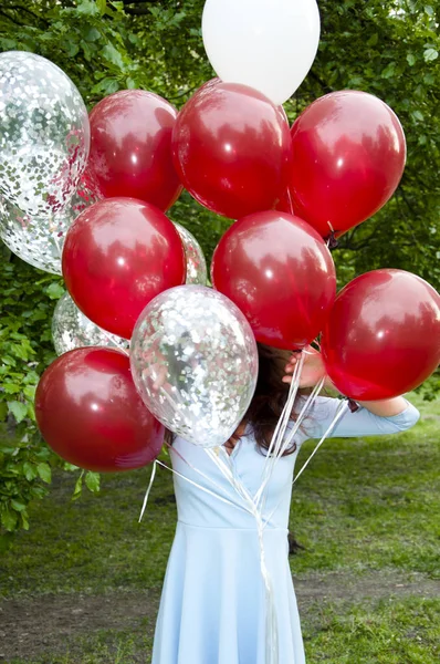 happy birthday. happy woman with party birthday baloons outdoor in summer. hiding.