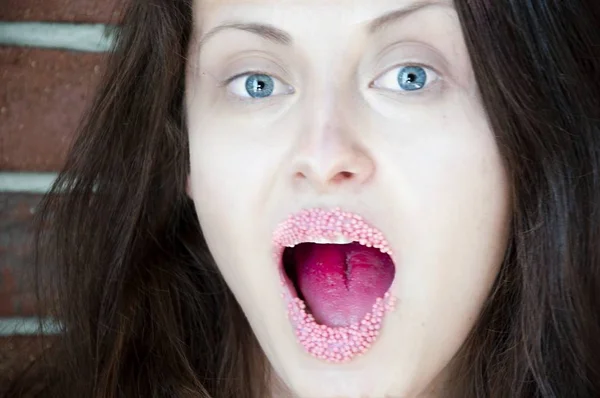 motions blurry picture of happy or surprised woman with pink sprinkles on lips