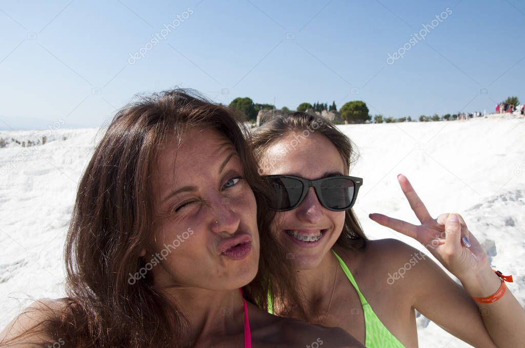 Friends making selfie. Natural travertine in Pamukkale. Beach. Summer vacation. Selfie. Dead sea salty shore. Sexy girl. Friendship. Cotton castle in Turkey. Happy frineds girls with suntan.