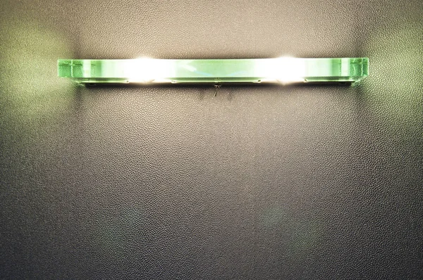 一个现代时尚的墙壁家庭玻璃绿色灯特写镜头照亮灰色纹理墙与内部背景的光 复制空间 — 图库照片