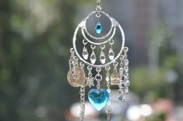 Catch the luck. Silver amulet with gems and pendants. Name amulet for good luck. Luck amulet hung out outdoor. Believing in magic protecting the holder of amulet. Jewelry charm or talisman.