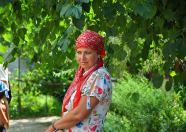 Geleneksel şal yeşil ağacın yanında açık sarı poz, güzel genç yetişkin kadın. Doğu motifleri
