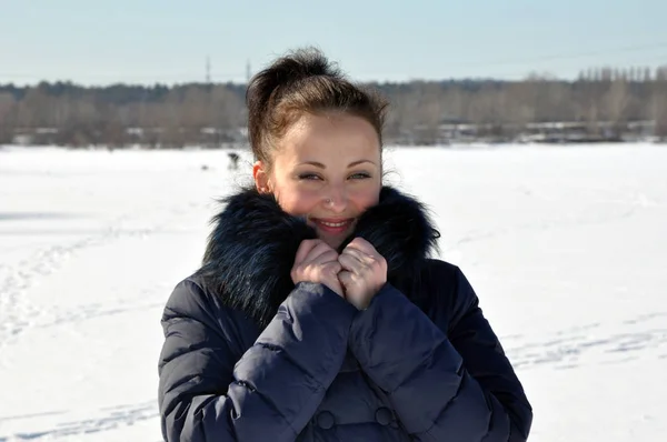 相当可爱的年轻黑发女孩在蓝色冬衣与毛皮阳光寒冷的冬天天在自然白色雪背景 — 图库照片