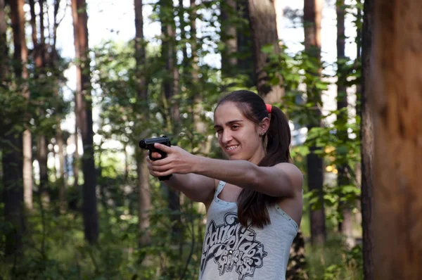 Woman with weapon. Gun in hand of shooter. Hunting and education outdoor in forest. Kill and war. Girl shooting from gun., aim and success