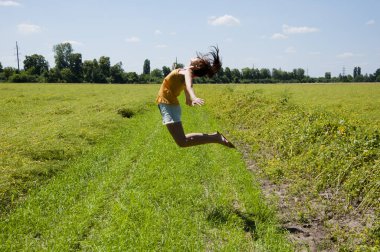 Özgürlük duygusu. Mutlu kız yükseğe zıplar. Mutluluk dolu. Rüyalarda uçup git. Sahadaki kadınların yaz aktiviteleri. spor ve jimnastik.