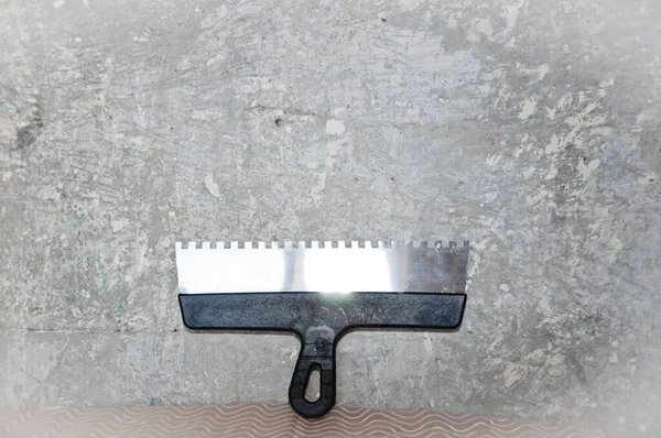 working with spackling. Damaged wall repair. putty knife on gray grunge cement wall background. spatula for repair and construction. building concept. work tool and equipment. workplace.