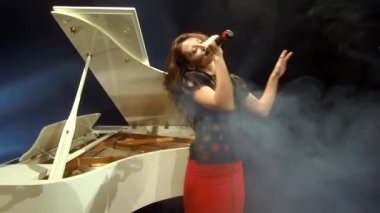 Klasik klasiklerde seksi bir kız sahnede pop soul blues söylüyor piyanoda, müzikte mikrofonda.