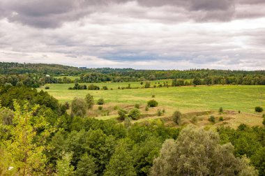Bulutlu gökyüzü ile dağlık bir manzara. Yeşil Tepe Dağı manzaralı. Vahşi dağda, orman ve yeşil vadiyle nefes kesici bir yaz günü. Vadisi olan bir dağ manzarası. Yaz parkı doğası..