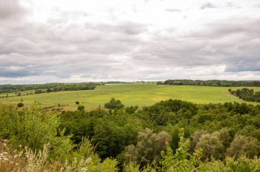 Yeşil Tepe Dağı manzaralı. Vahşi dağda, orman ve yeşil vadiyle nefes kesici bir yaz günü. Vadisi olan bir dağ manzarası. Bulutlu gökyüzü ile dağlık bir manzara. Dağ vadisi.