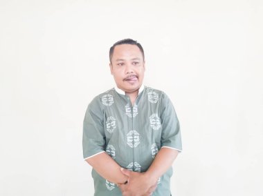 Beyaz arka planda gri kıyafetler giyen, kahverengi tenli Asyalı bir adamın ifadesi.