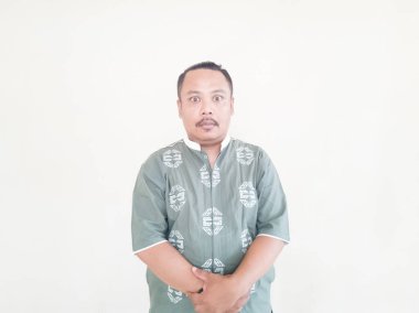 Beyaz arka planda gri kıyafetler giyen, kahverengi tenli Asyalı bir adamın ifadesi.