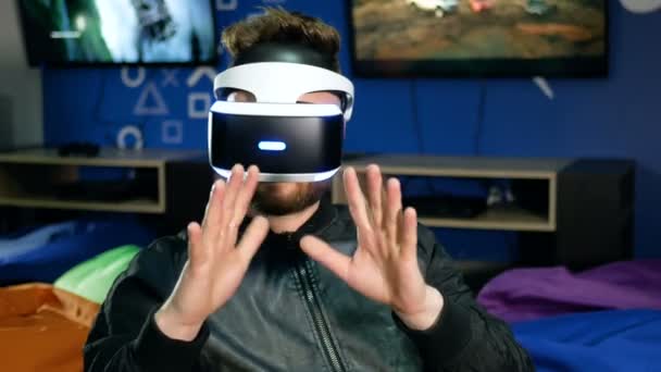 Bearded guy looks at his hands through virtual reality glasses — Stock Video