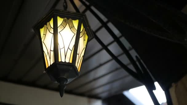 La caméra tourne autour d'une lanterne allumée qui pend sous le toit. Dispositifs d'éclairage dans des cadres métalliques . — Video