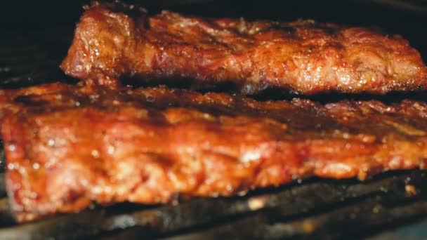 Barbecued pork ribs lie on the grill. Juicy meat dish. — Stock Video