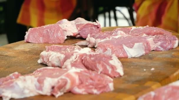 El carnicero corta carne cruda en trozos para filetes, los golpea con un martillo para la mejor preparación. Proceso de trabajo en la cocina del restaurante . — Vídeo de stock