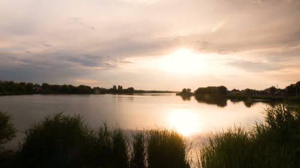 Timelapse ηλιοβασίλεμα μέσα από όμορφα σύννεφα στη λίμνη. Τέλος της ημέρας στο χρόνο. Ρεύματα αέρα. — Αρχείο Βίντεο